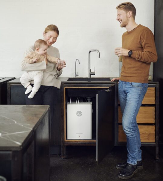 En ung familie drikker vand og har en vandrensningsmaskine installeret